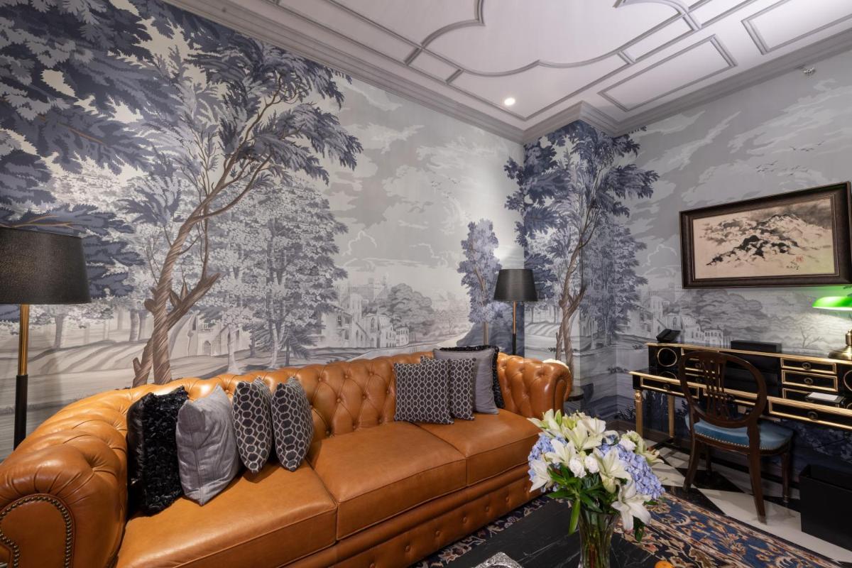 a living room with a couch and a wall mural at The Claridges New Delhi in New Delhi a living room with a couch and a wall mural at The Claridges New Delhi in New Delhi