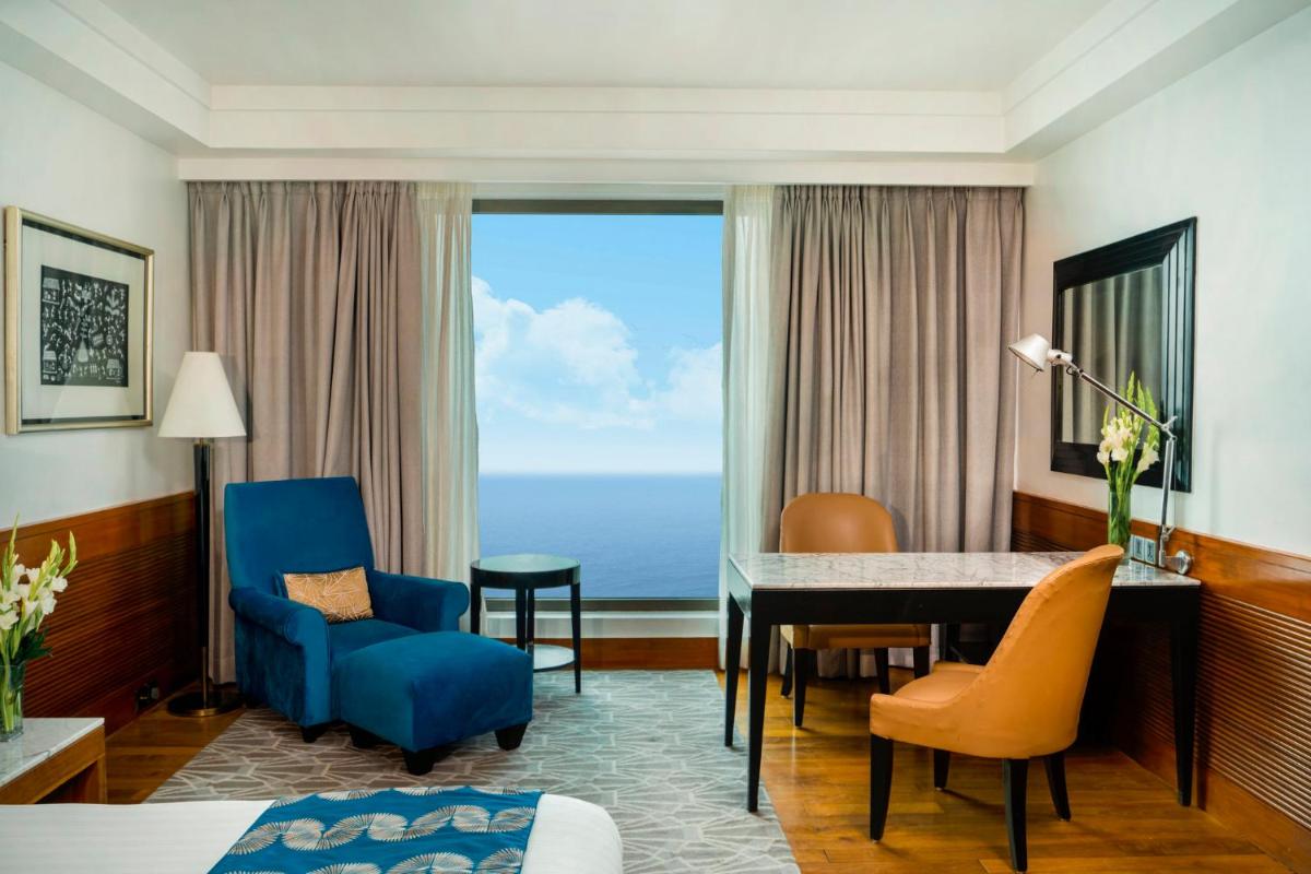 a hotel room with a desk and chairs and a table at InterContinental Marine Drive Mumbai by IHG in Mumbai