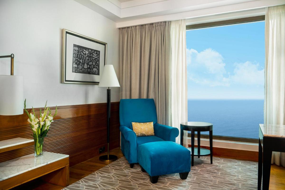 a room with a blue chair and a desk and a window at InterContinental Marine Drive Mumbai by IHG in Mumbai