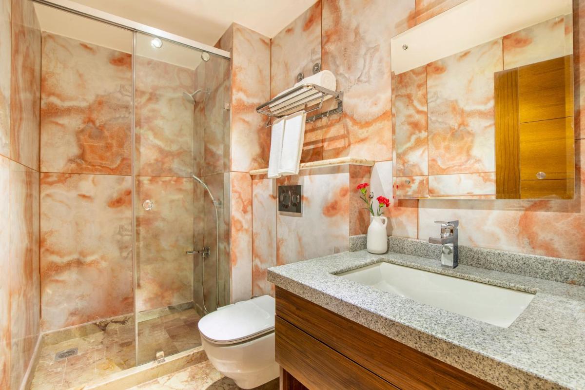 a bathroom with a sink and a toilet and a shower at The Prominence Mussoorie Road Dehradun in Dehradun