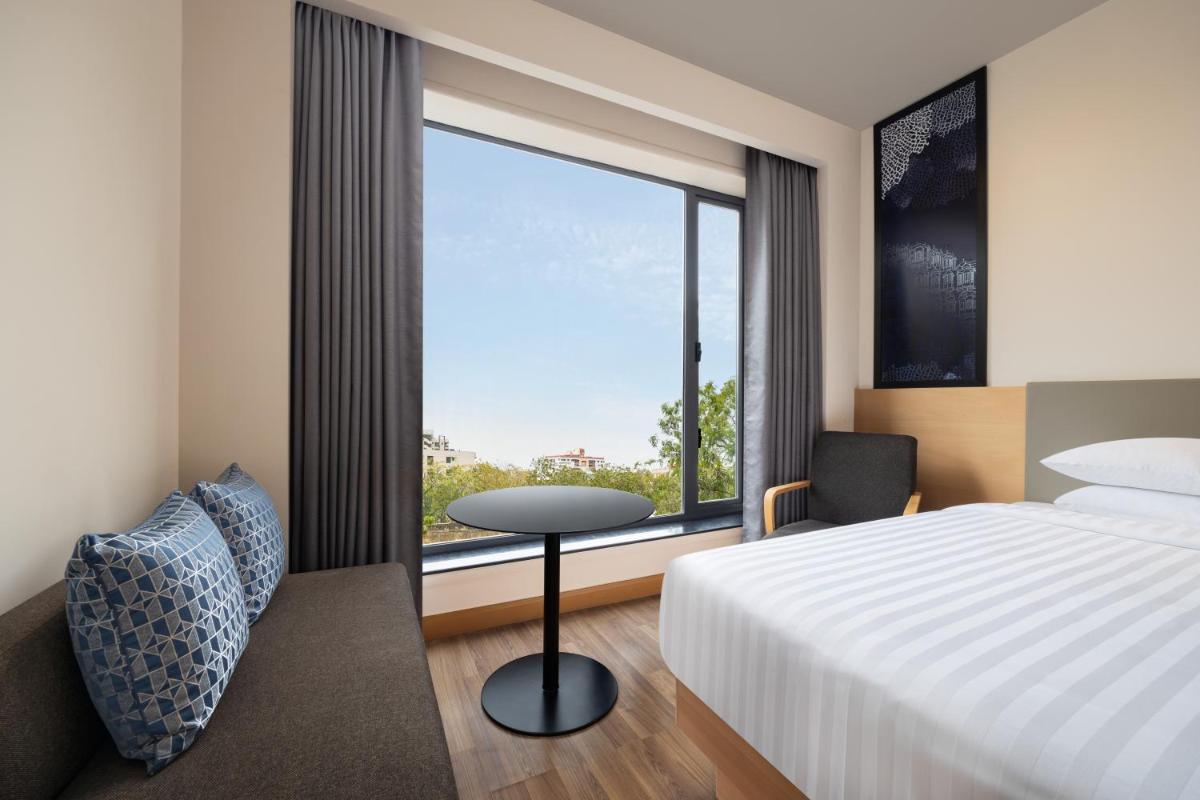 a hotel room with a bed and a window at Fairfield by Marriott Jaipur in Jaipur