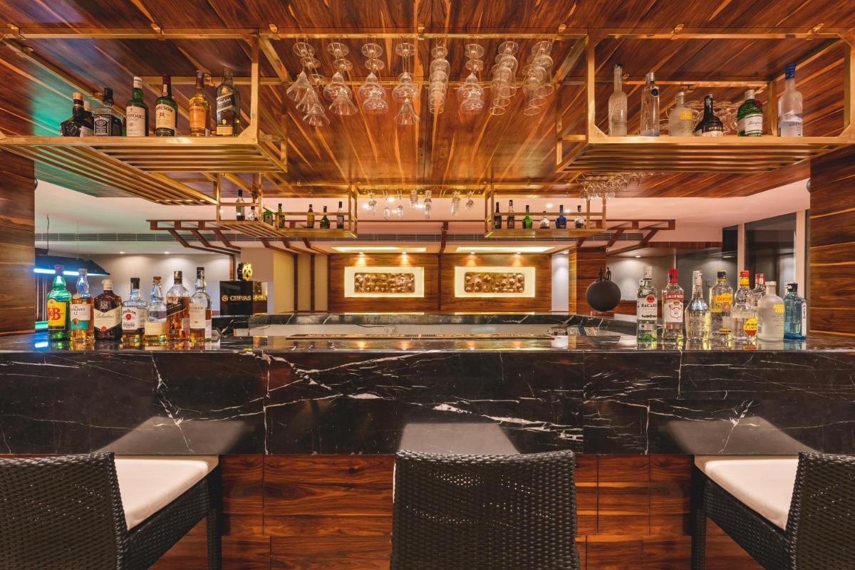a bar with a black marble counter and chairs at Welcomhotel by ITC Hotels, Shimla in Shimla