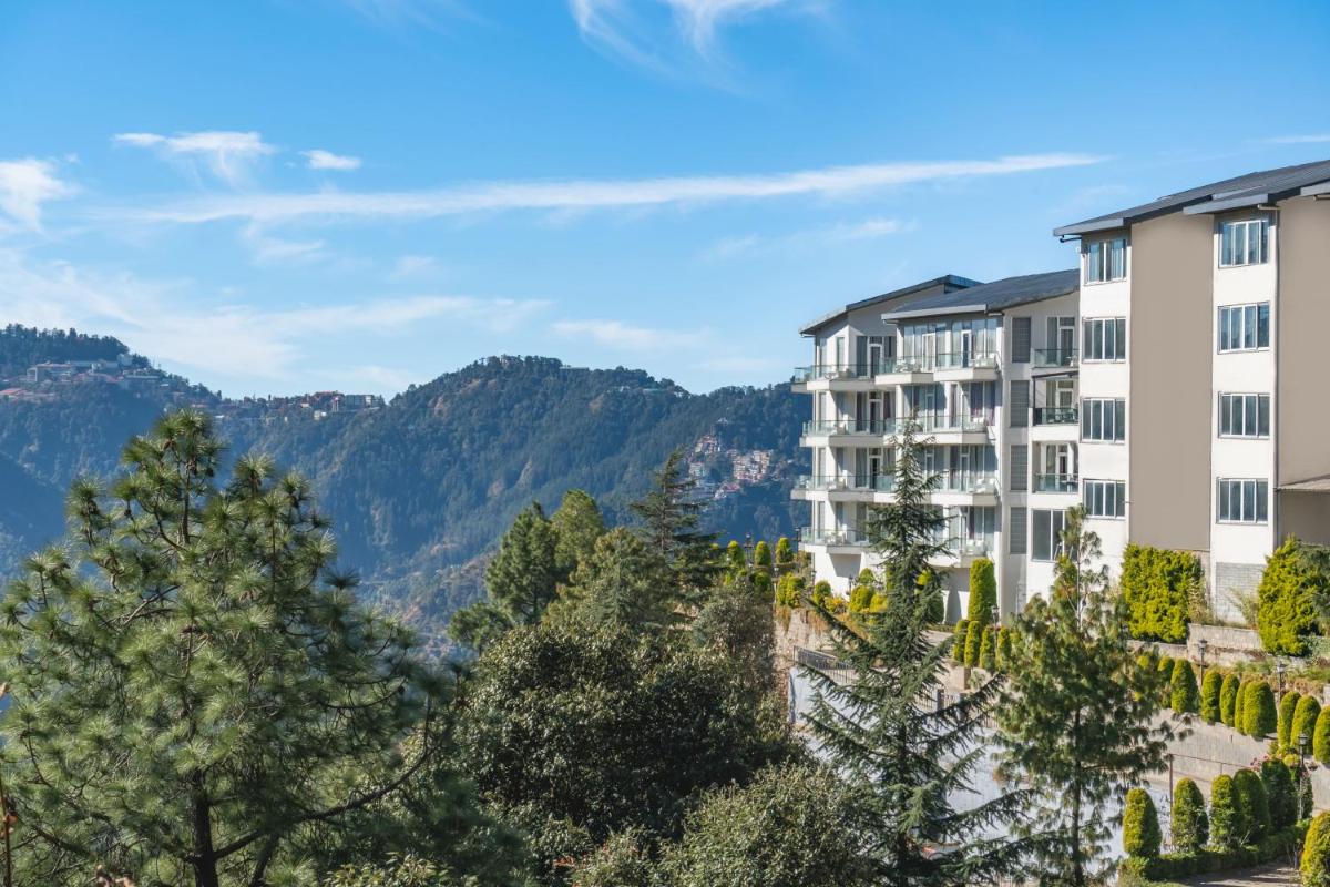 a view of a building with mountains in the background at Welcomhotel by ITC Hotels, Shimla in Shimla