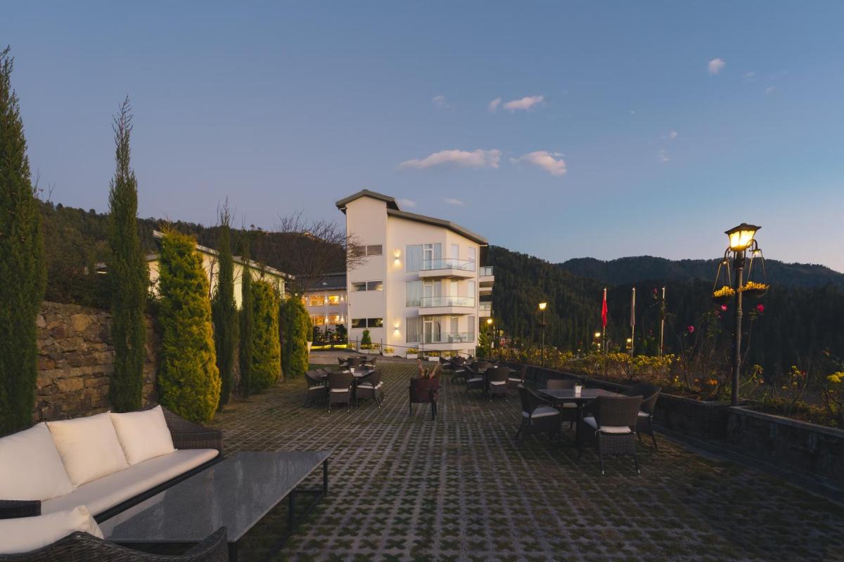 a building with couches and chairs on a brick patio at Welcomhotel by ITC Hotels, Shimla in Shimla