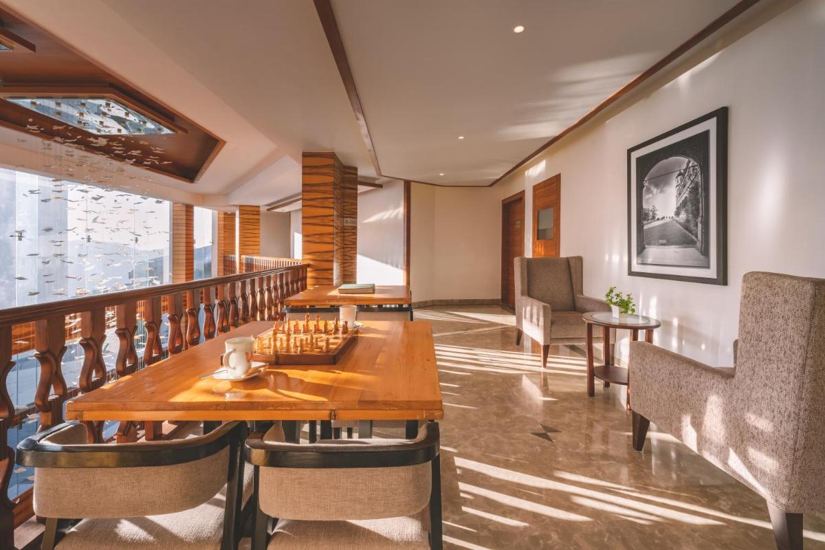 a restaurant with tables and chairs on a balcony at Welcomhotel by ITC Hotels, Shimla in Shimla