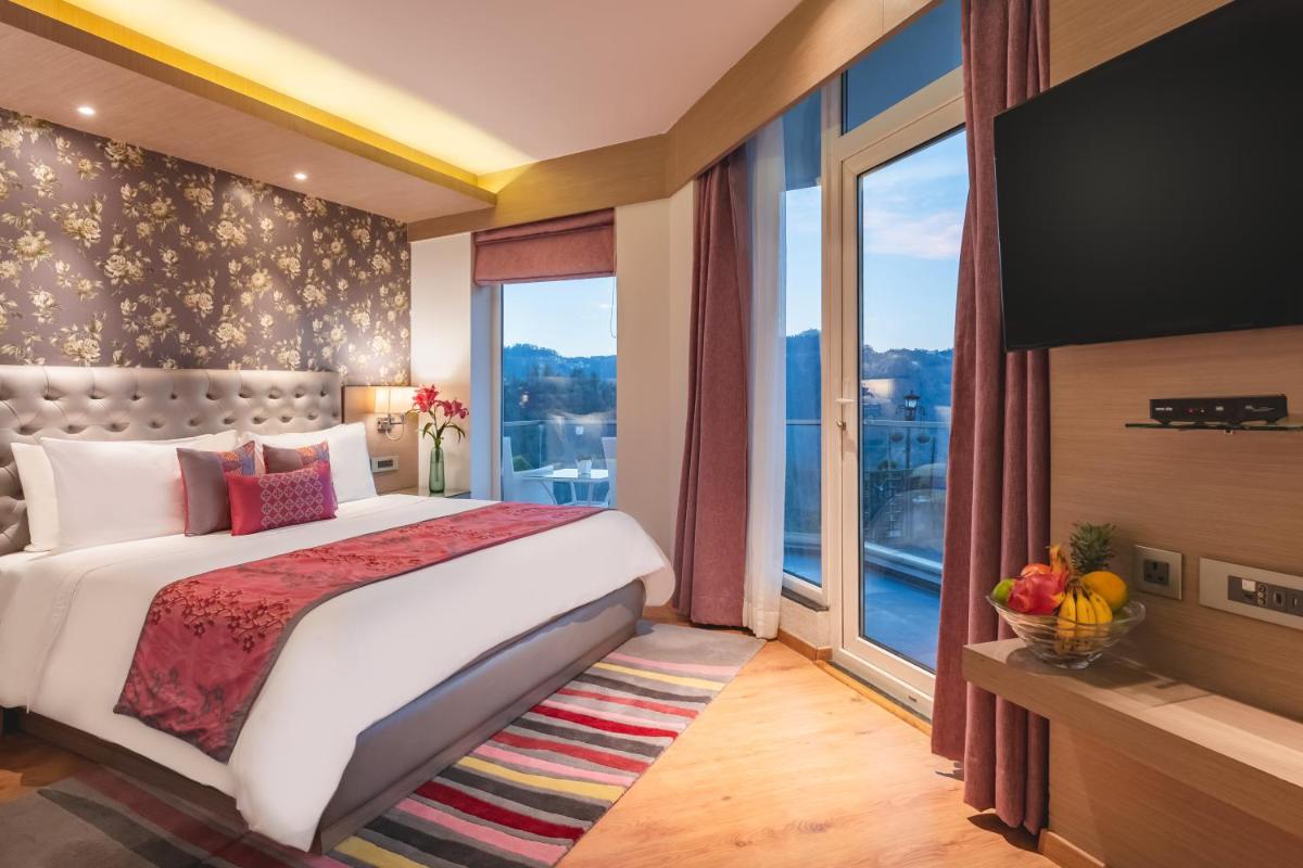 a bedroom with a large bed and a large window at Welcomhotel by ITC Hotels, Shimla in Shimla