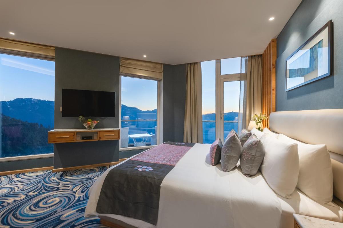 a bedroom with a large bed and a large window at Welcomhotel by ITC Hotels, Shimla in Shimla