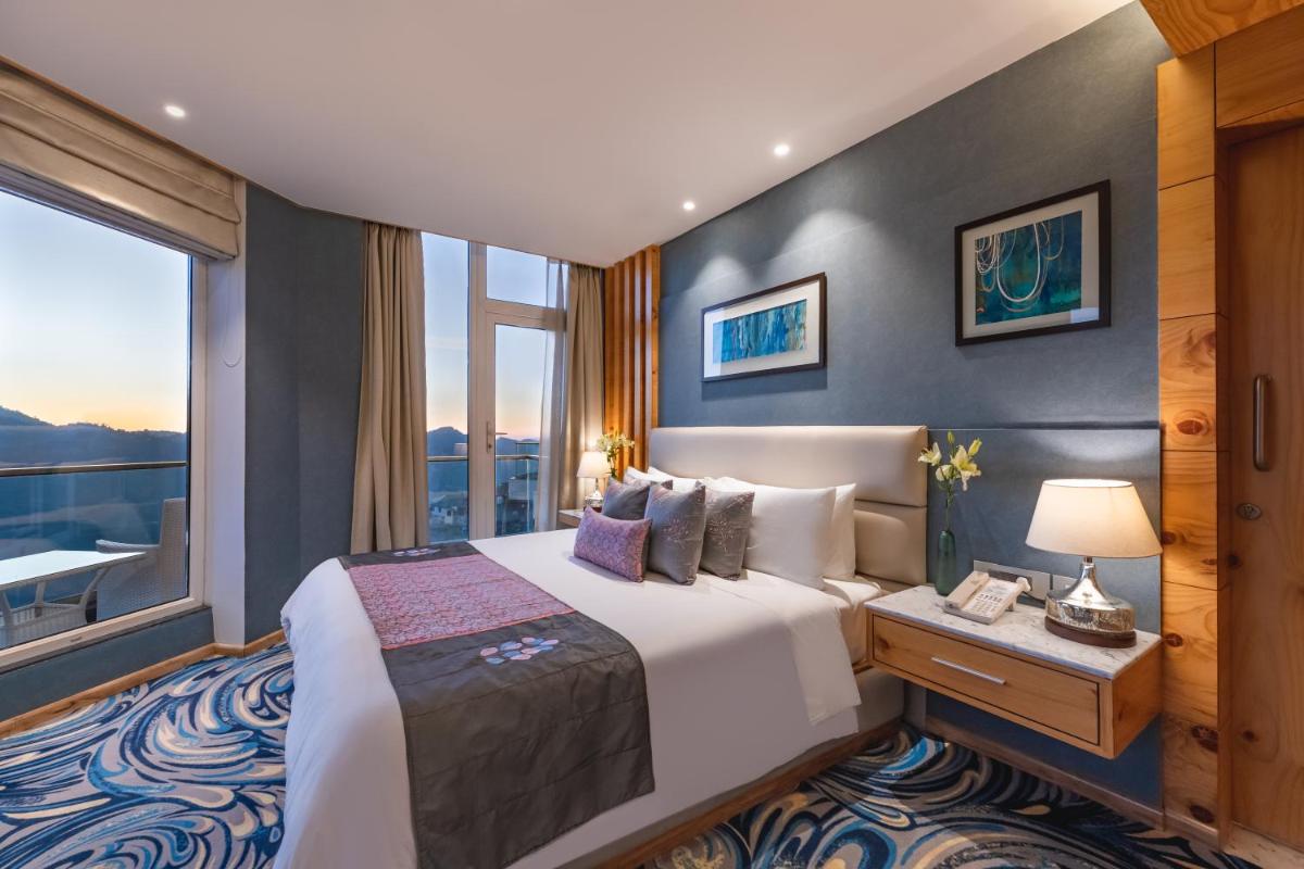 a hotel room with a bed and a large window at Welcomhotel by ITC Hotels, Shimla in Shimla