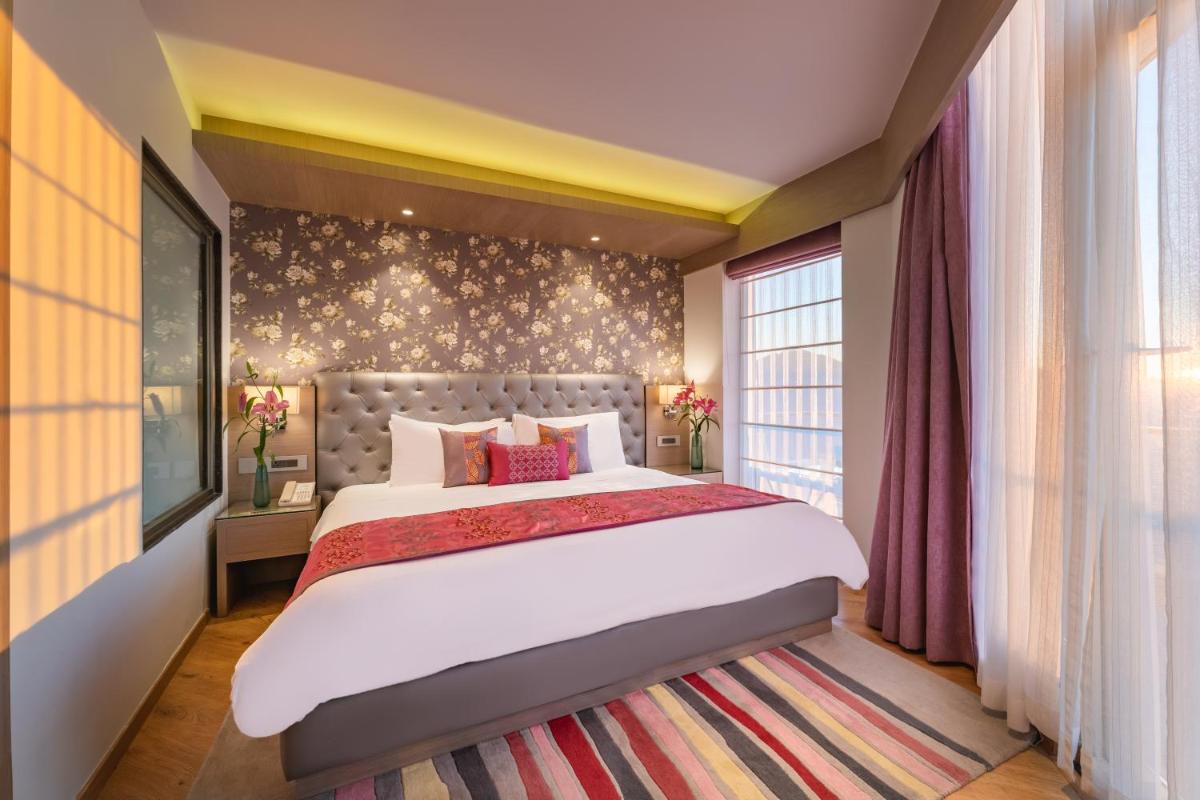a bedroom with a large bed and a large window at Welcomhotel by ITC Hotels, Shimla in Shimla