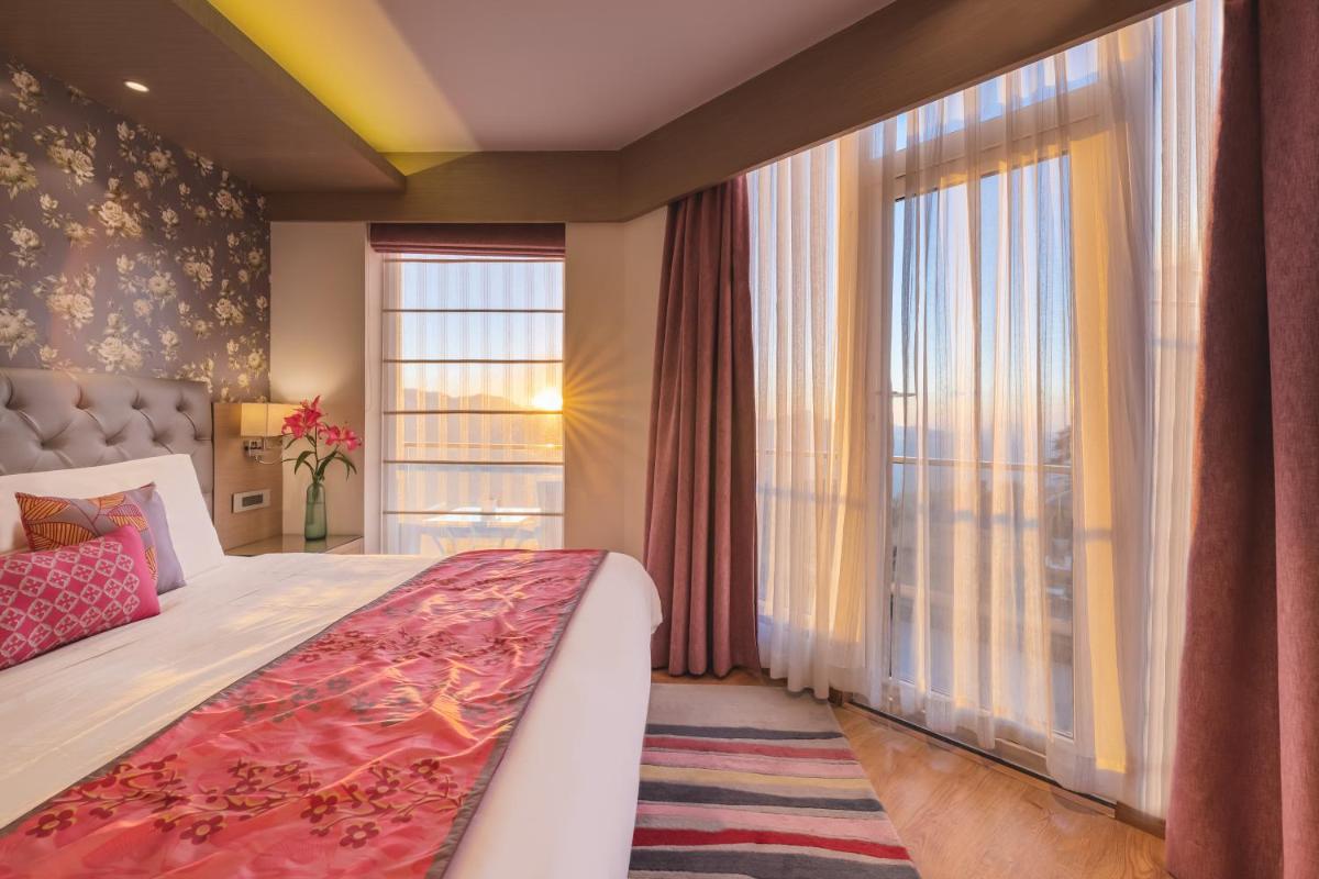 a bedroom with a bed and a large window at Welcomhotel by ITC Hotels, Shimla in Shimla