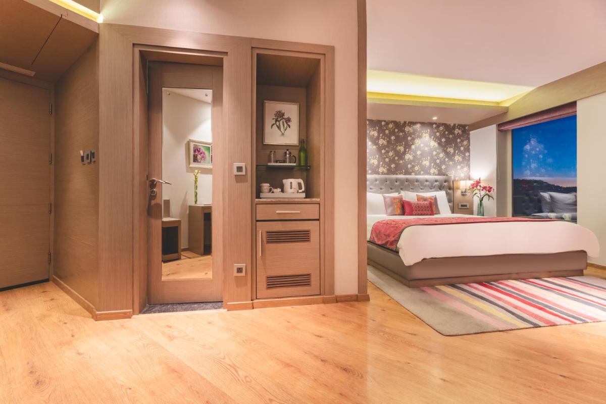 a bedroom with a bed and a large window at Welcomhotel by ITC Hotels, Shimla in Shimla