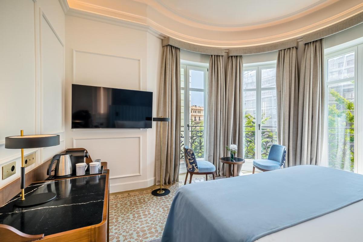Una habitación de hotel con una cama y un televisor de pantalla plana. en Palacio Gran Vía, a Royal Hideaway Hotel, en Granada