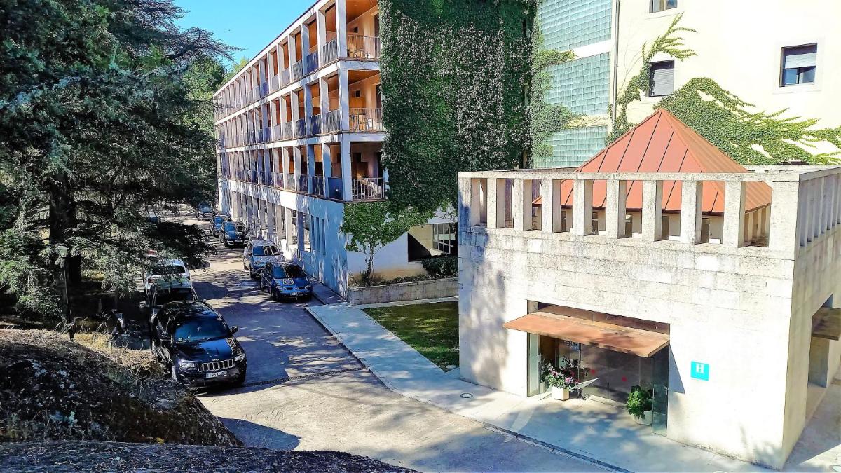 un edificio con un coche estacionado al lado de una calle en Hotel Balneario de Retortillo, en Retortillo