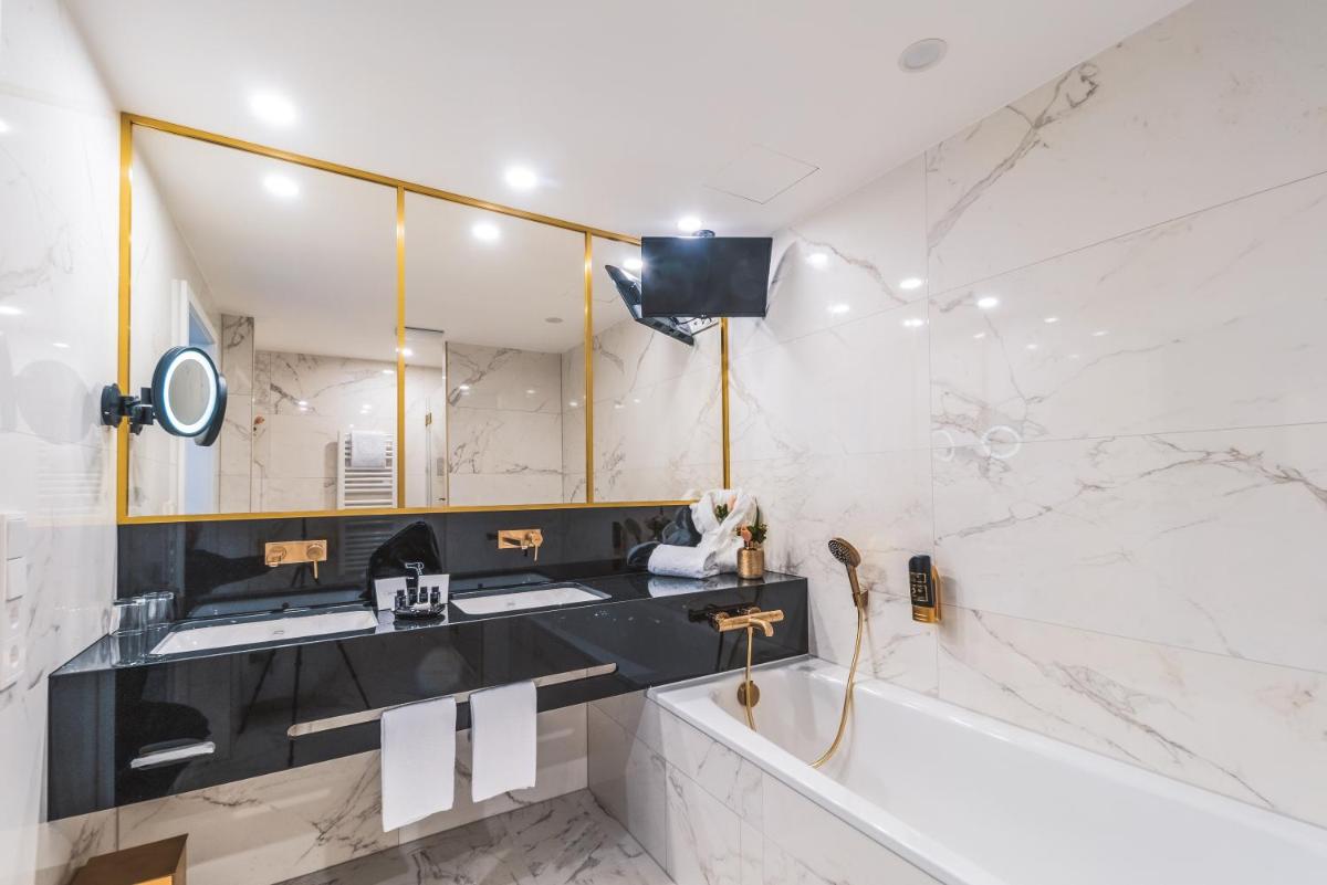 ein Badezimmer mit Waschbecken und Spiegel in der Unterkunft Hotel Suitess in Dresden + 37 Fotos ein Badezimmer mit Waschbecken und Spiegel in der Unterkunft Hotel Suitess in Dresden + 37 Fotos