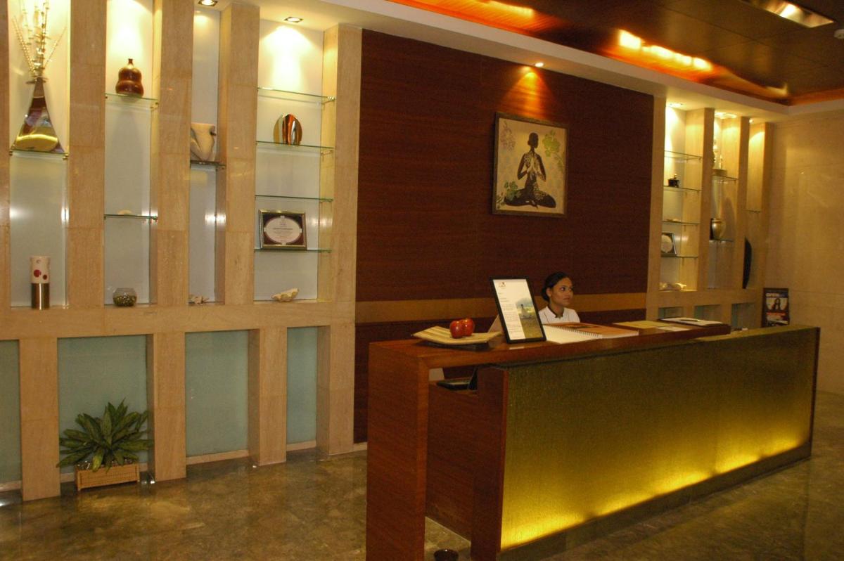 a woman sitting at a reception desk in a lobby at The LaLiT New Delhi in New Delhi