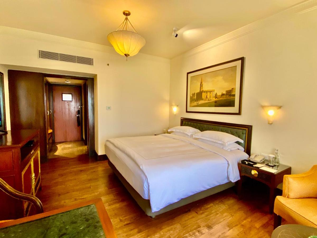 a bedroom with a large white bed and a couch at Taj Bengal in Kolkata