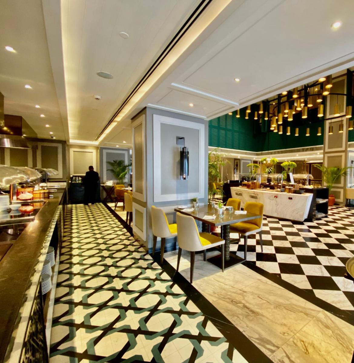 a restaurant with a checkered floor and tables and chairs at Taj Bengal in Kolkata