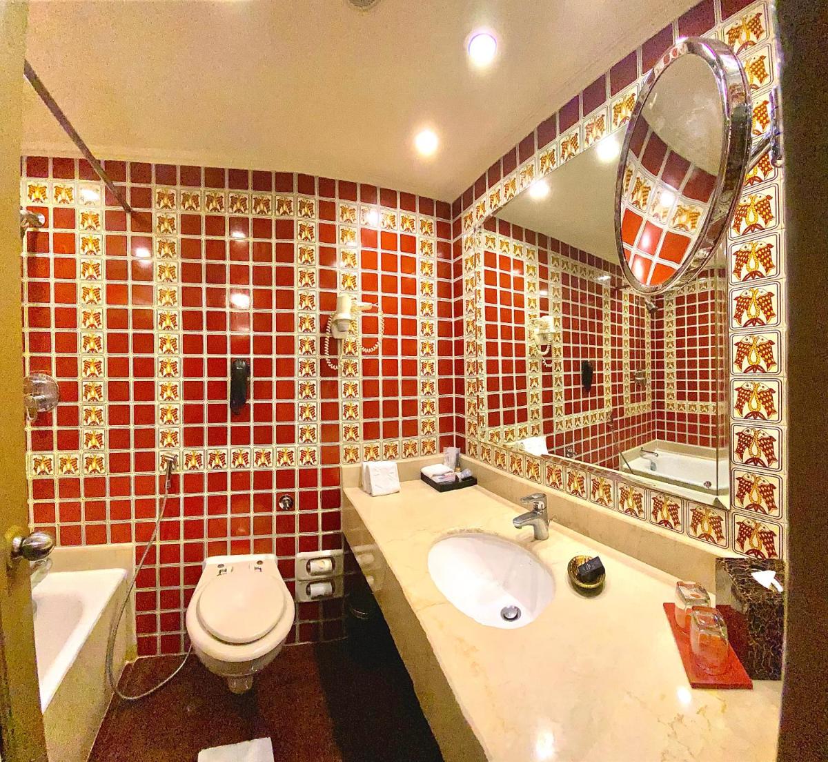 a bathroom with a sink and a toilet and a mirror at Taj Bengal in Kolkata