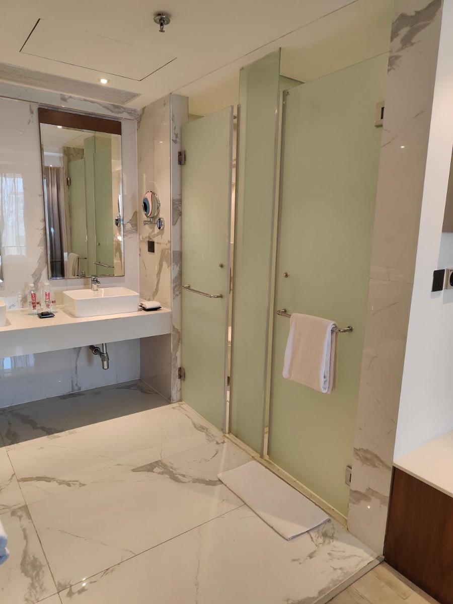 a bathroom with a sink and a shower at Le Meridien Hyderabad in Hyderabad