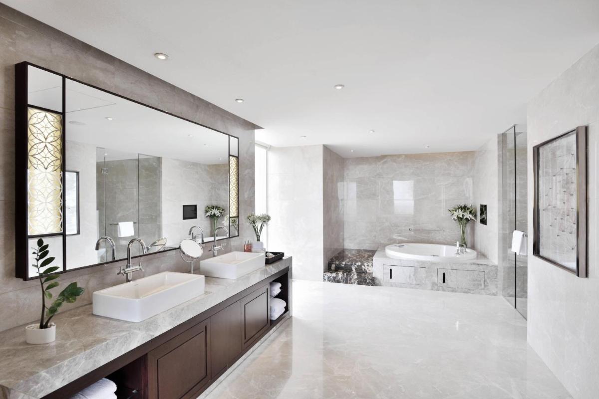 a bathroom with two sinks and a large mirror at Kochi Marriott Hotel in Cochin