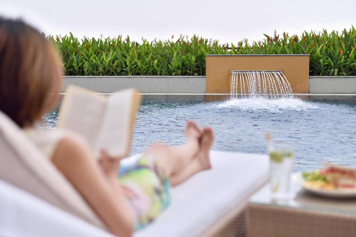 a child laying in a chair next to a swimming pool at Kochi Marriott Hotel in Cochin