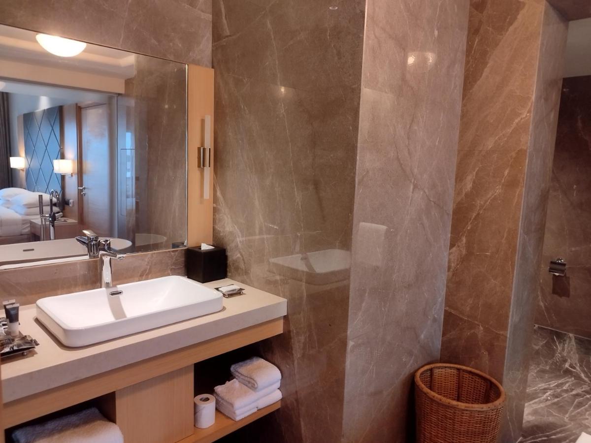 a bathroom with a sink and a mirror at Courtyard by Marriott Tiruchirappalli in Tiruchchirāppalli