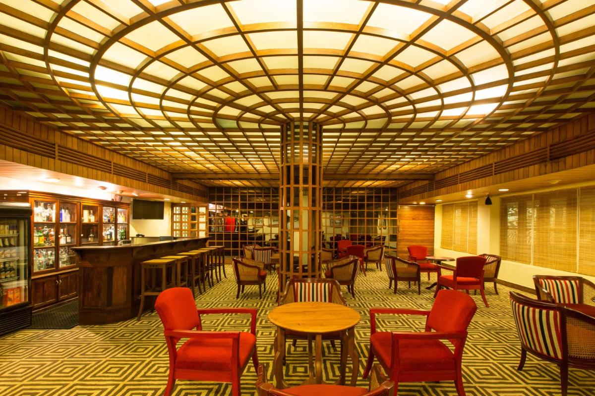 a lobby with chairs and tables and a large ceiling at Casino Hotel - CGH Earth, Cochin in Cochin
