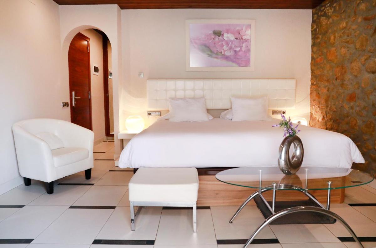 Un dormitorio con una cama, una mesa y una silla. en La Violeta HOTEL SPA & CHILL OUT, en Castelltersol 17 fotos más