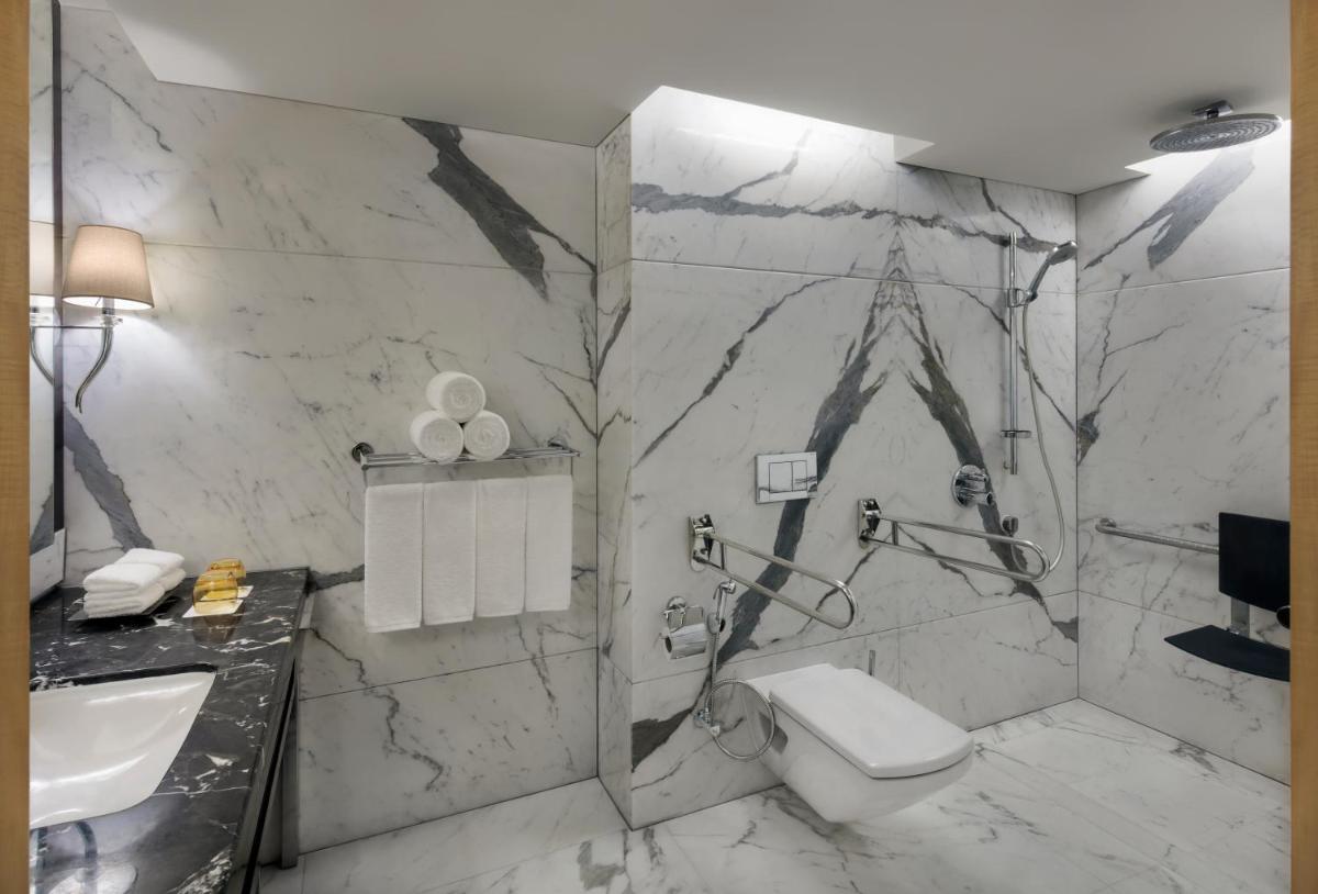 a bathroom with a toilet and a sink at JW Marriott Mumbai Juhu in Mumbai