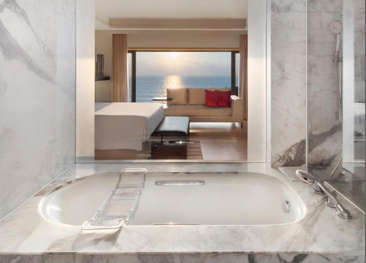 a bath tub in a room with a bedroom at JW Marriott Mumbai Juhu in Mumbai