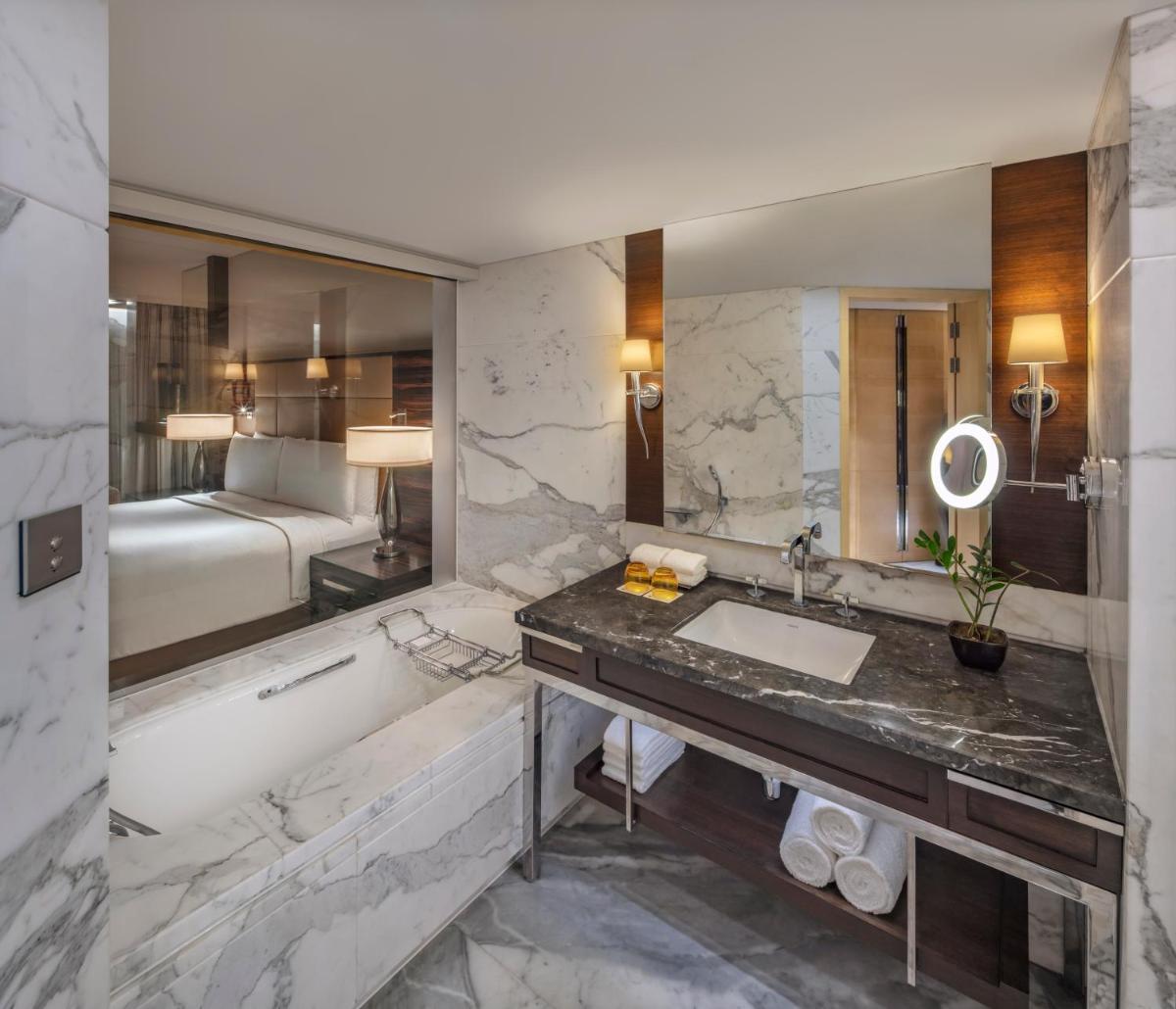 a bathroom with a tub and a sink and a bath tub at JW Marriott Mumbai Juhu in Mumbai