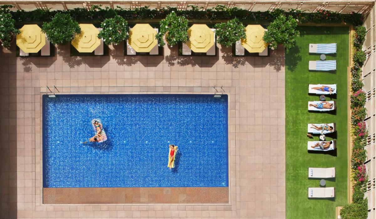 an overhead view of a swimming pool with people in it at President - IHCL SeleQtions in Mumbai