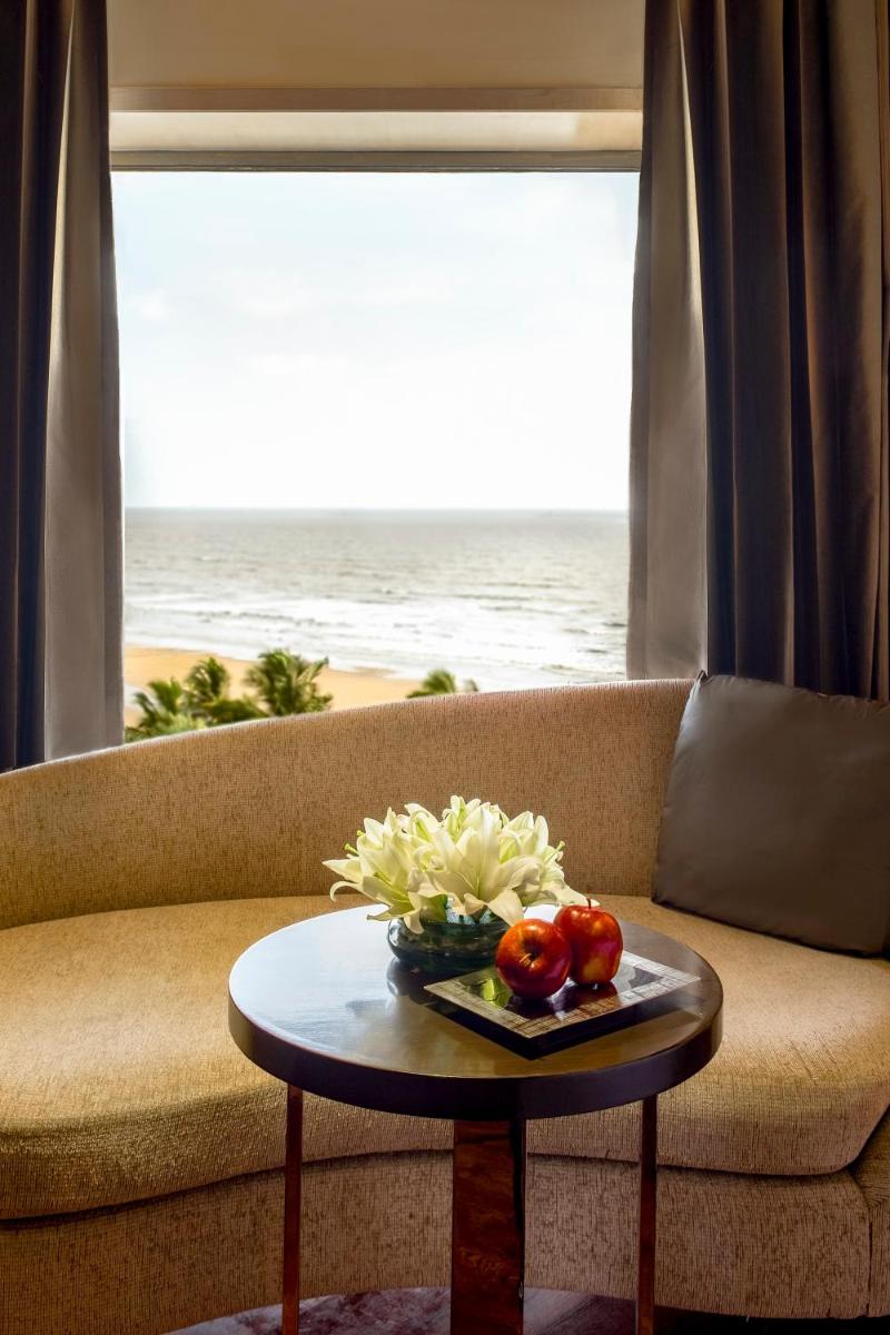 a living room with a couch and a table with fruit at JW Marriott Mumbai Juhu in Mumbai