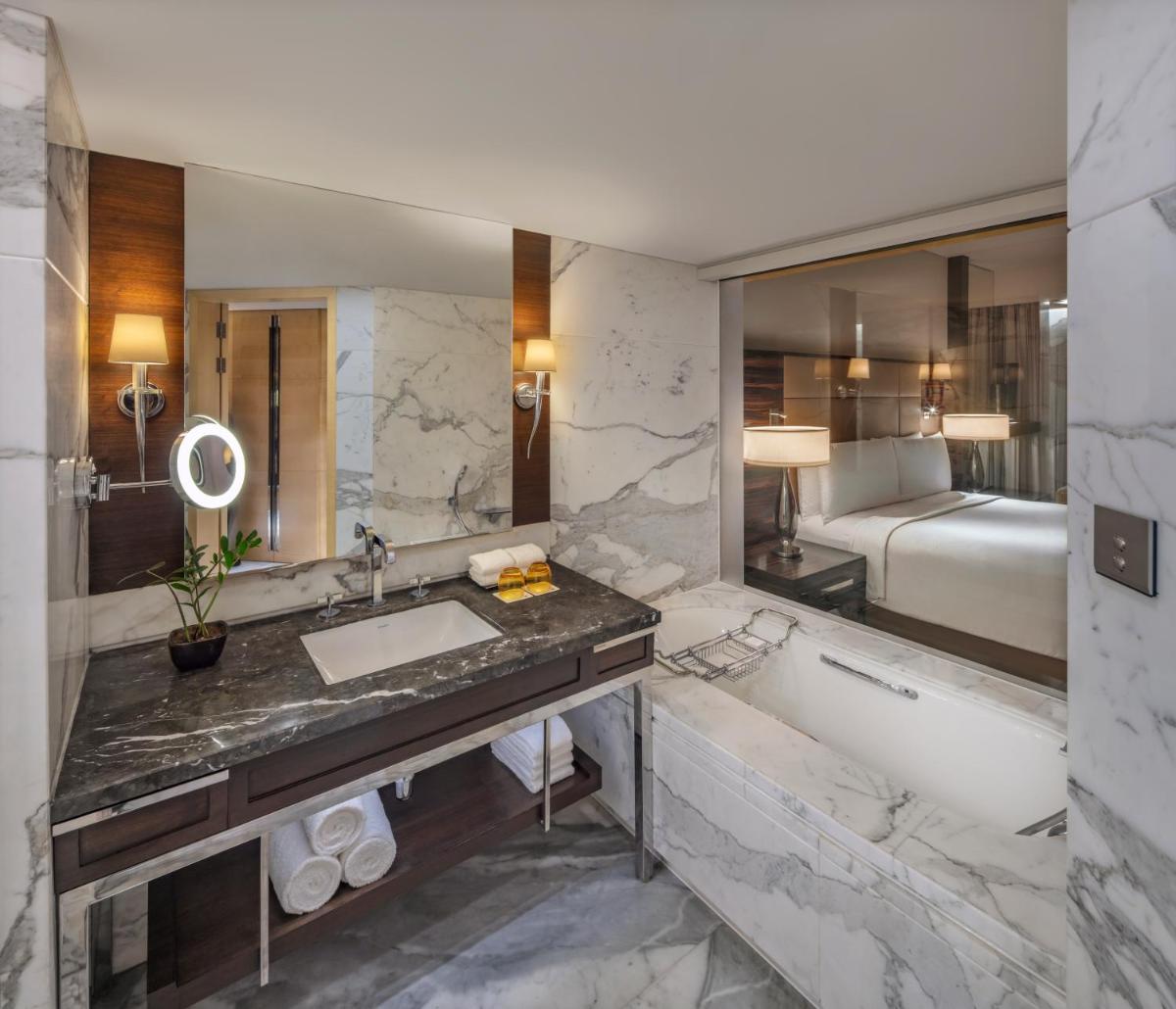 a bathroom with a tub and a sink and a bath tub at JW Marriott Mumbai Juhu in Mumbai