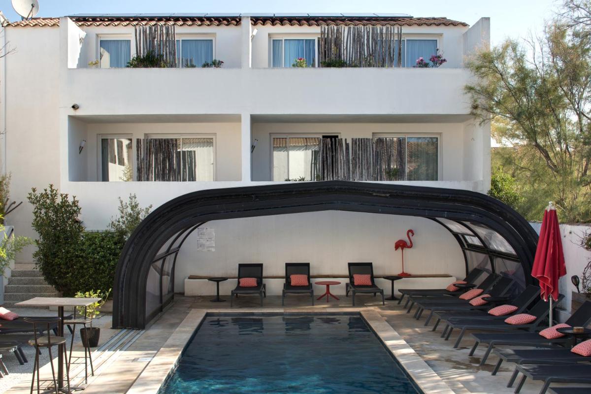 - une piscine en face d'un bâtiment avec des chaises et des tables dans l'établissement Vila De La Mar & Spa, à Saintes-Maries-de-la-Mer