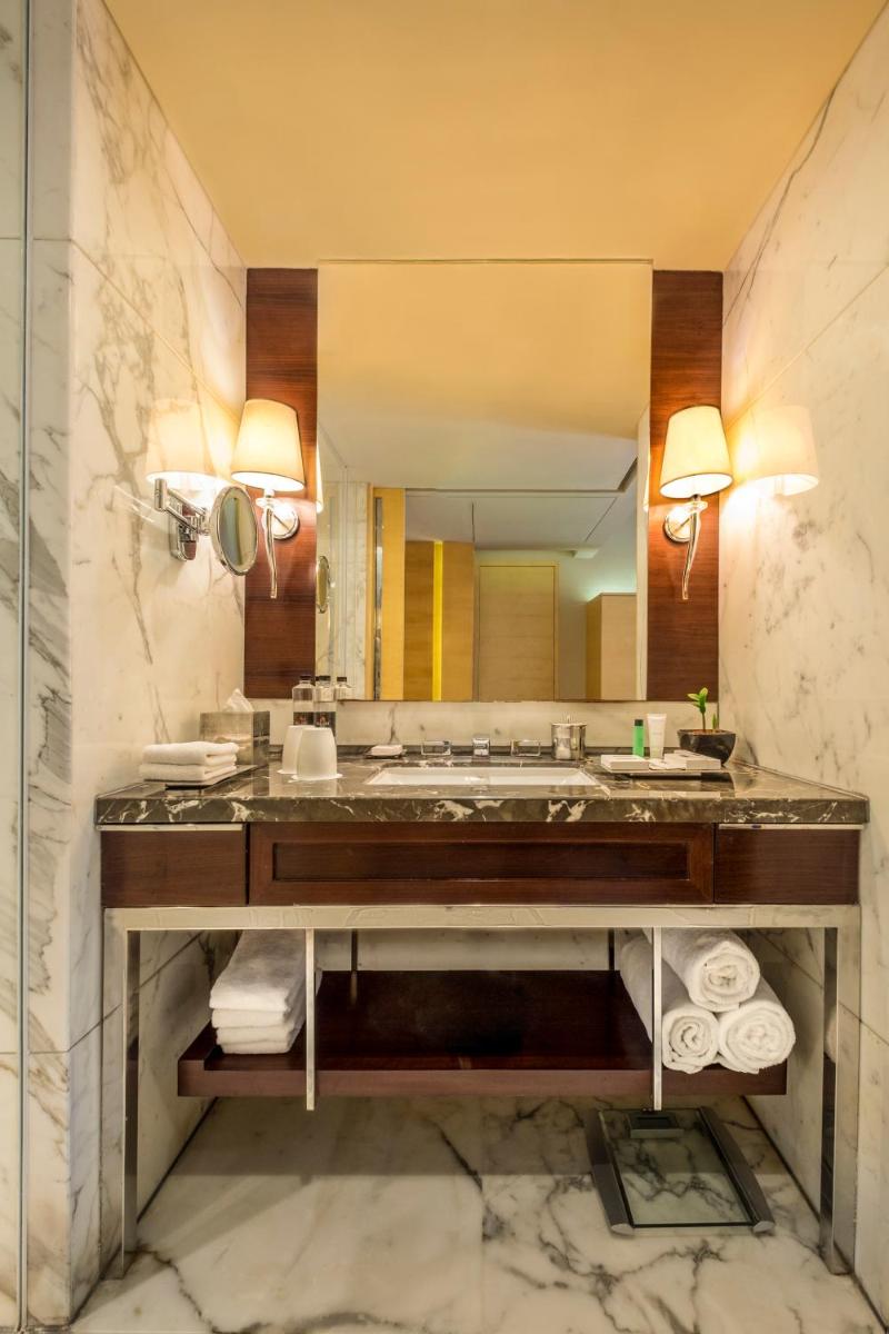 a bathroom with a sink and a large mirror at JW Marriott Mumbai Juhu in Mumbai