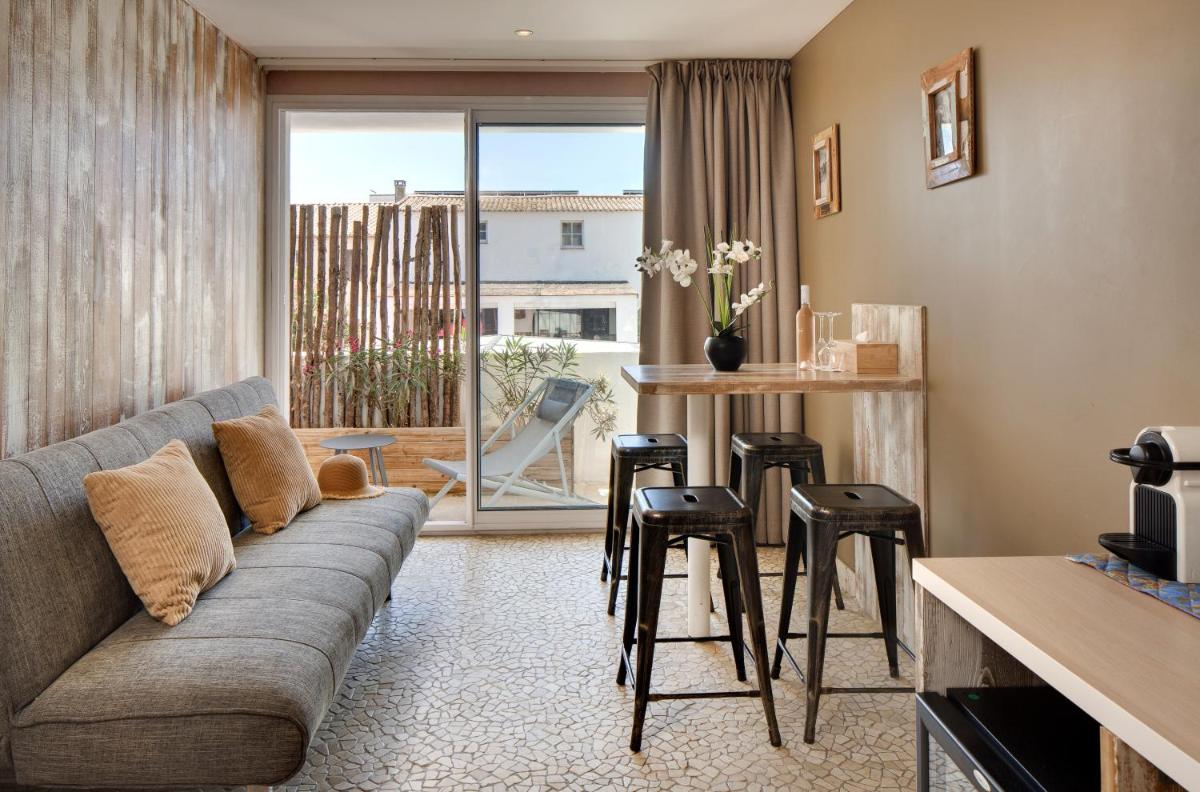 - un salon avec un canapé et une table avec des tabourets dans l'établissement Vila De La Mar & Spa, à Saintes-Maries-de-la-Mer