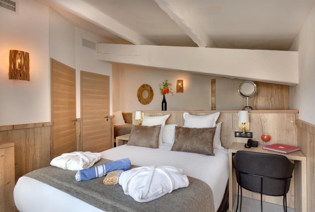 une chambre avec un grand lit blanc avec deux oreillers dans l'établissement Vila De La Mar & Spa, à Saintes-Maries-de-la-Mer