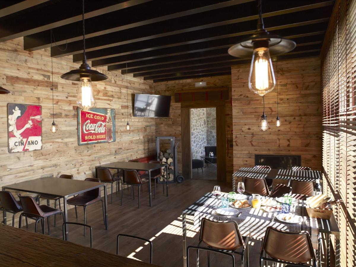 Un restaurante con mesas y sillas en una habitación. en Hotel Boutique Puig Francó - Adults Only, en Camprodon