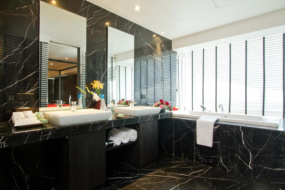 a bathroom with two sinks and two mirrors at Svenska Design Hotel in Mumbai a bathroom with two sinks and two mirrors at Svenska Design Hotel in Mumbai