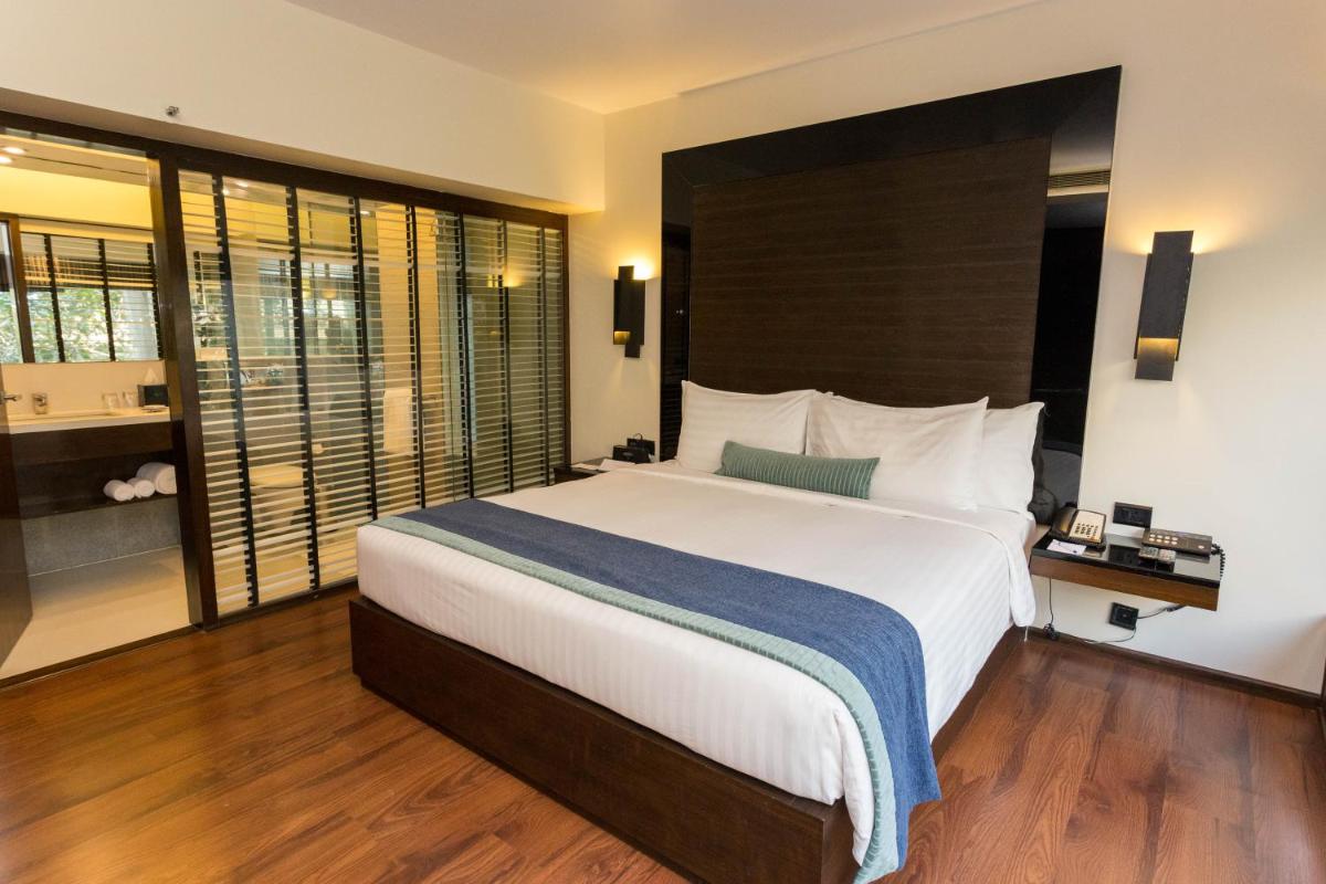 a bedroom with a large bed and a large window at Svenska Design Hotel in Mumbai