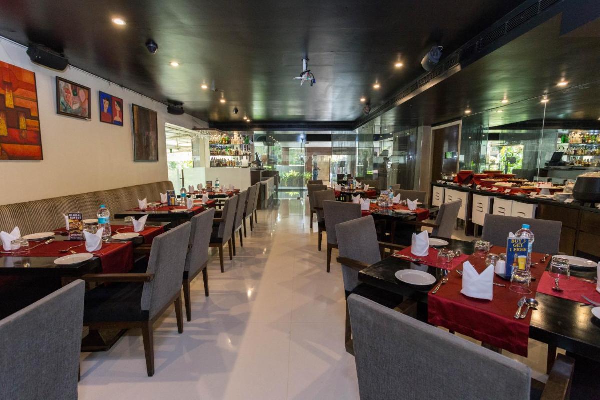 a dining room with tables and chairs and a restaurant at Svenska Design Hotel in Mumbai a dining room with tables and chairs and a restaurant at Svenska Design Hotel in Mumbai