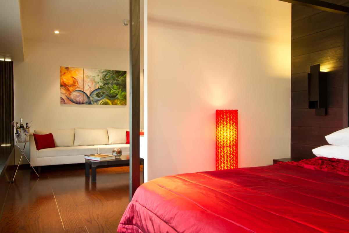a hotel room with a red bed and a couch at Svenska Design Hotel in Mumbai