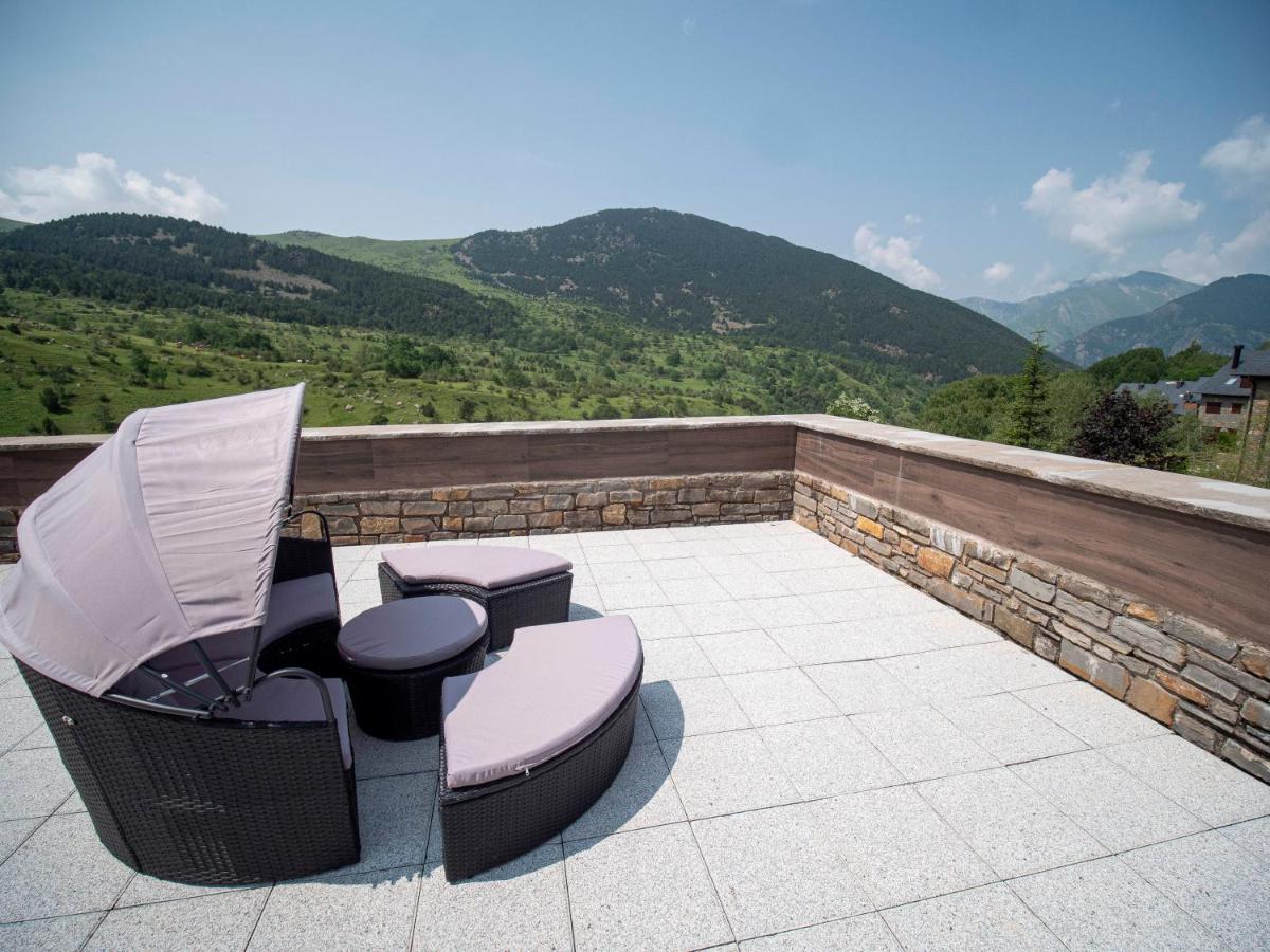 un patio con 2 sillas y vistas a las montañas en Aparthotel Siente Boí & SPA, en Pla de l'Ermita 131 fotos más