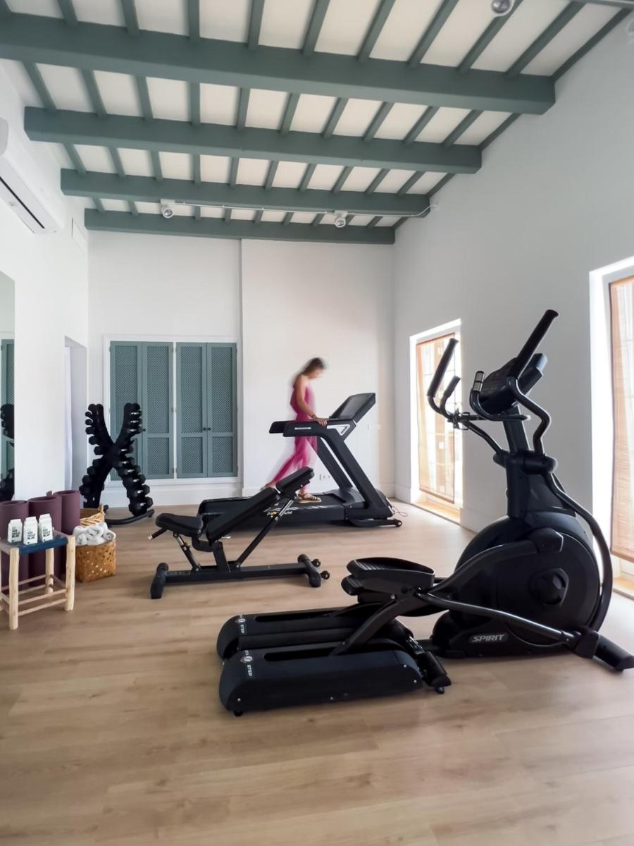 una sala de fitness con cintas de correr y bicicletas estáticas en Cristine Bedfor Mahon, en Mahón