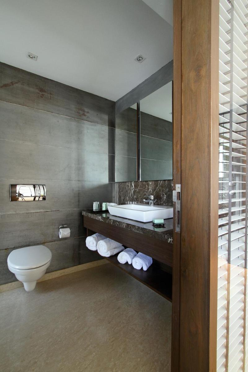 a bathroom with a sink and a toilet and a mirror at Svenska Design Hotel in Mumbai