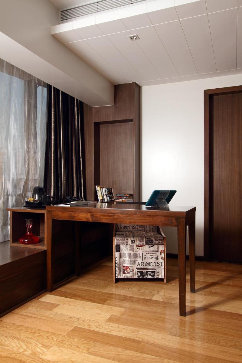 an office with a wooden desk with a laptop on it at Svenska Design Hotel in Mumbai