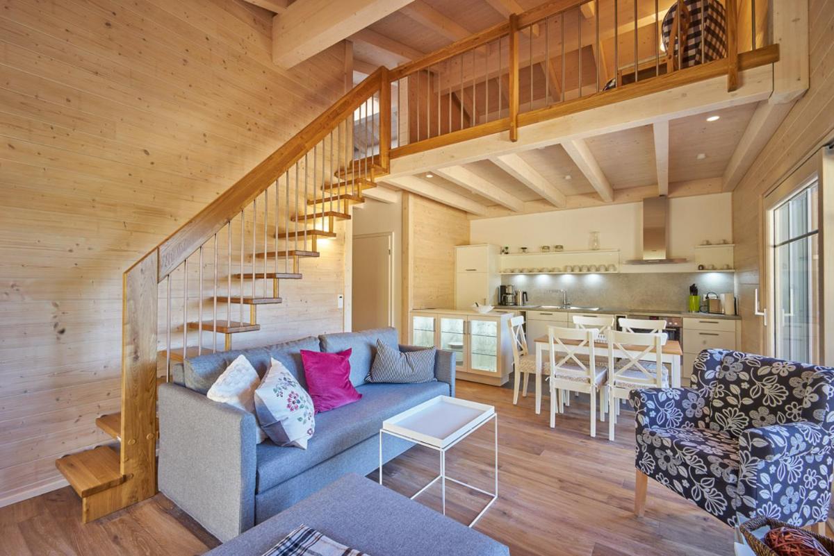 ein Wohnzimmer mit einem blauen Sofa und einer Treppe in der Unterkunft Alb Appartements in Albstadt