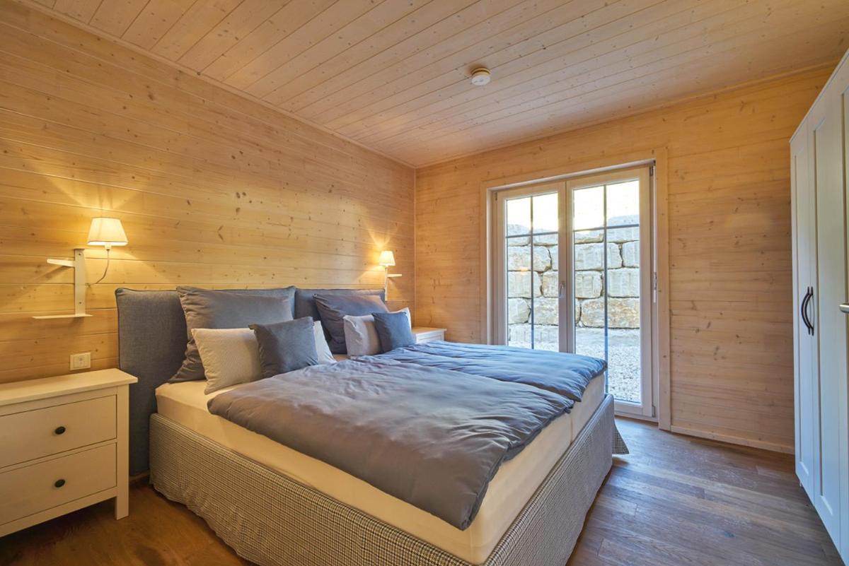 ein Schlafzimmer mit einem Bett mit einer Holzwand in der Unterkunft Alb Appartements in Albstadt