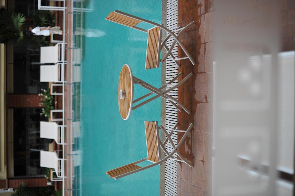 a metal wall clock on the side of a building at Deltin Suites in Candolim